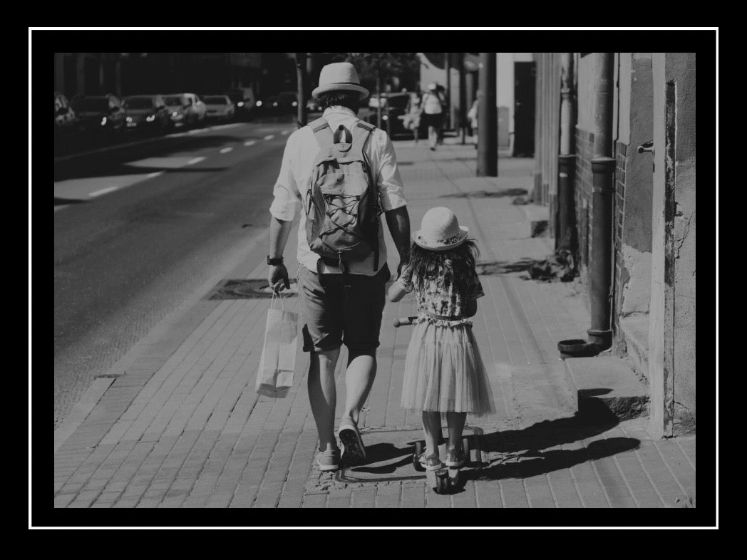 black and white image of father and daughter walking