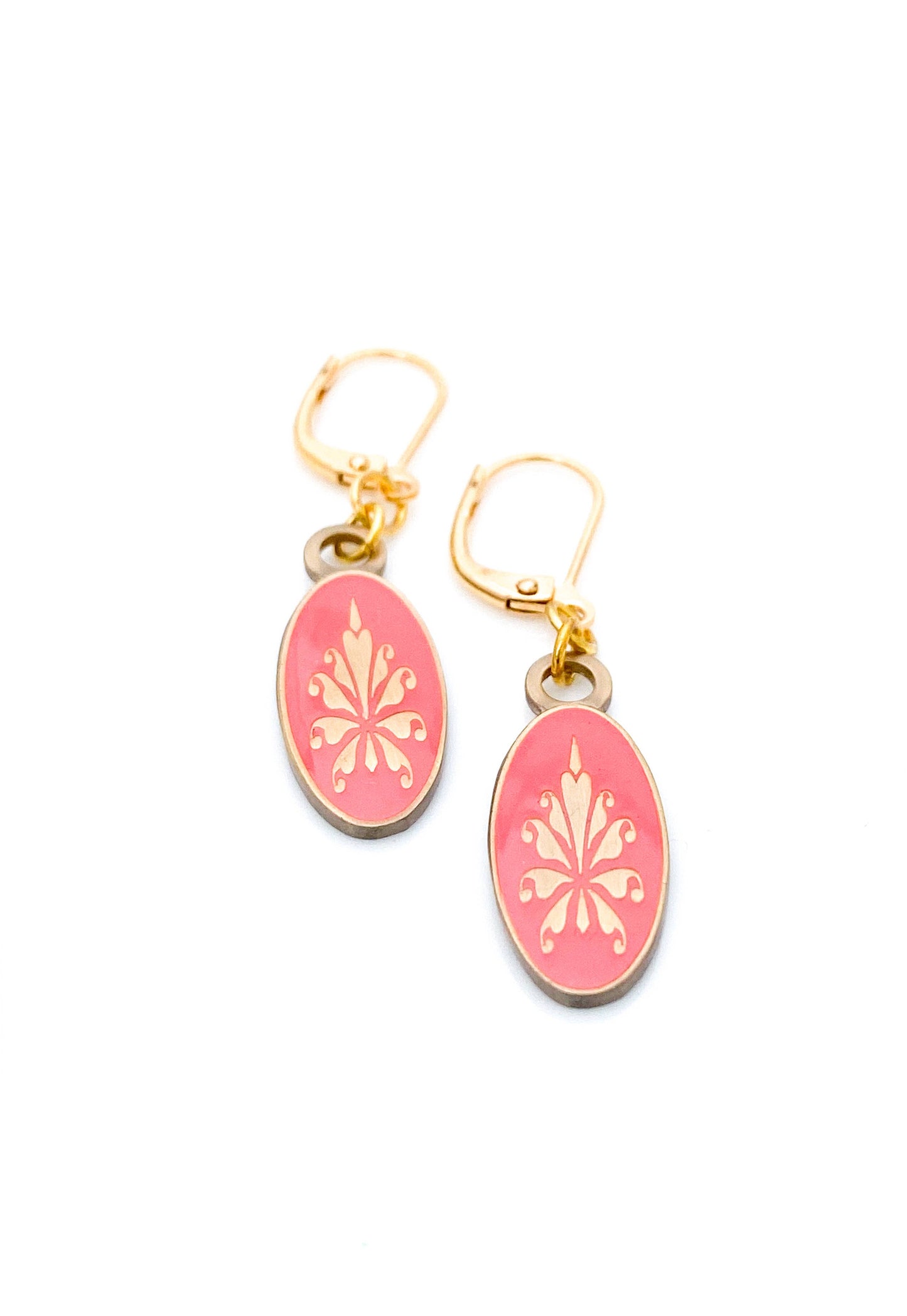 Antiqued gold oval earrings with fleur de lys pattern on coral enamel