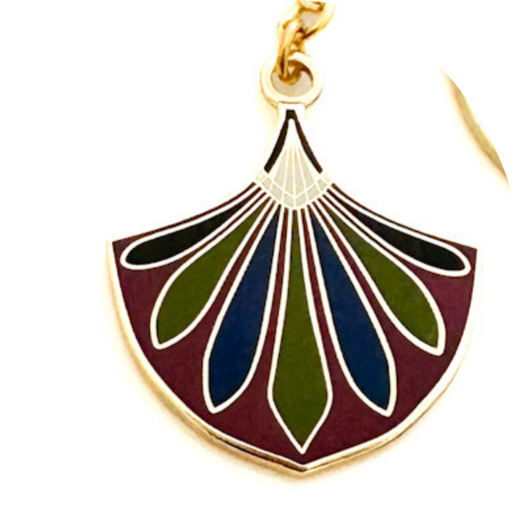 Decorative pendant with gold frame, blue, green, and red design on a white background