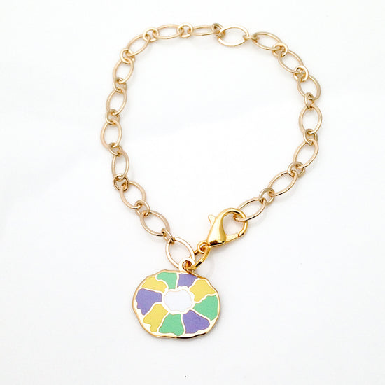 Gold chain bracelet with a colorful pendant on a white background