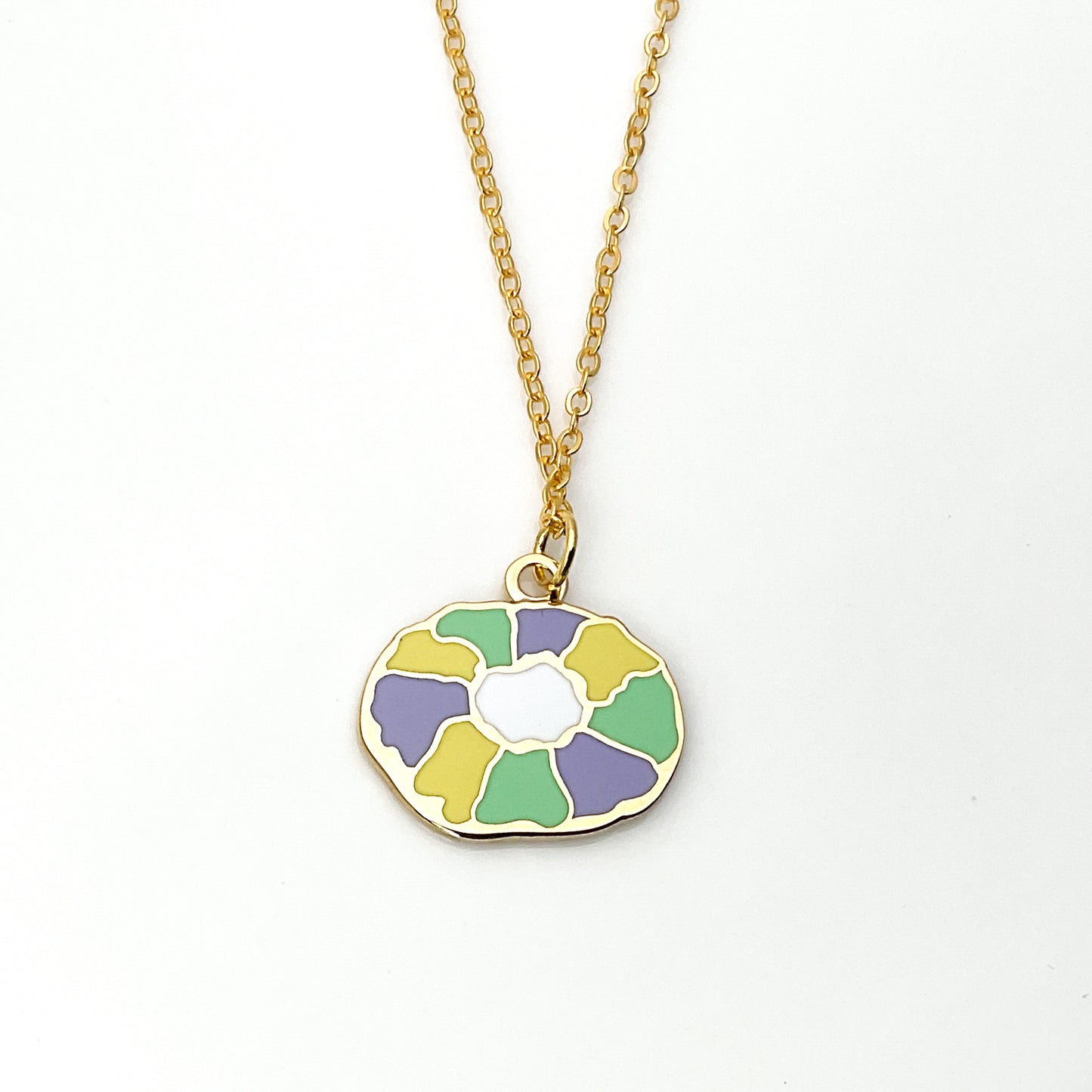Colorful floral pendant on a gold chain against a white background