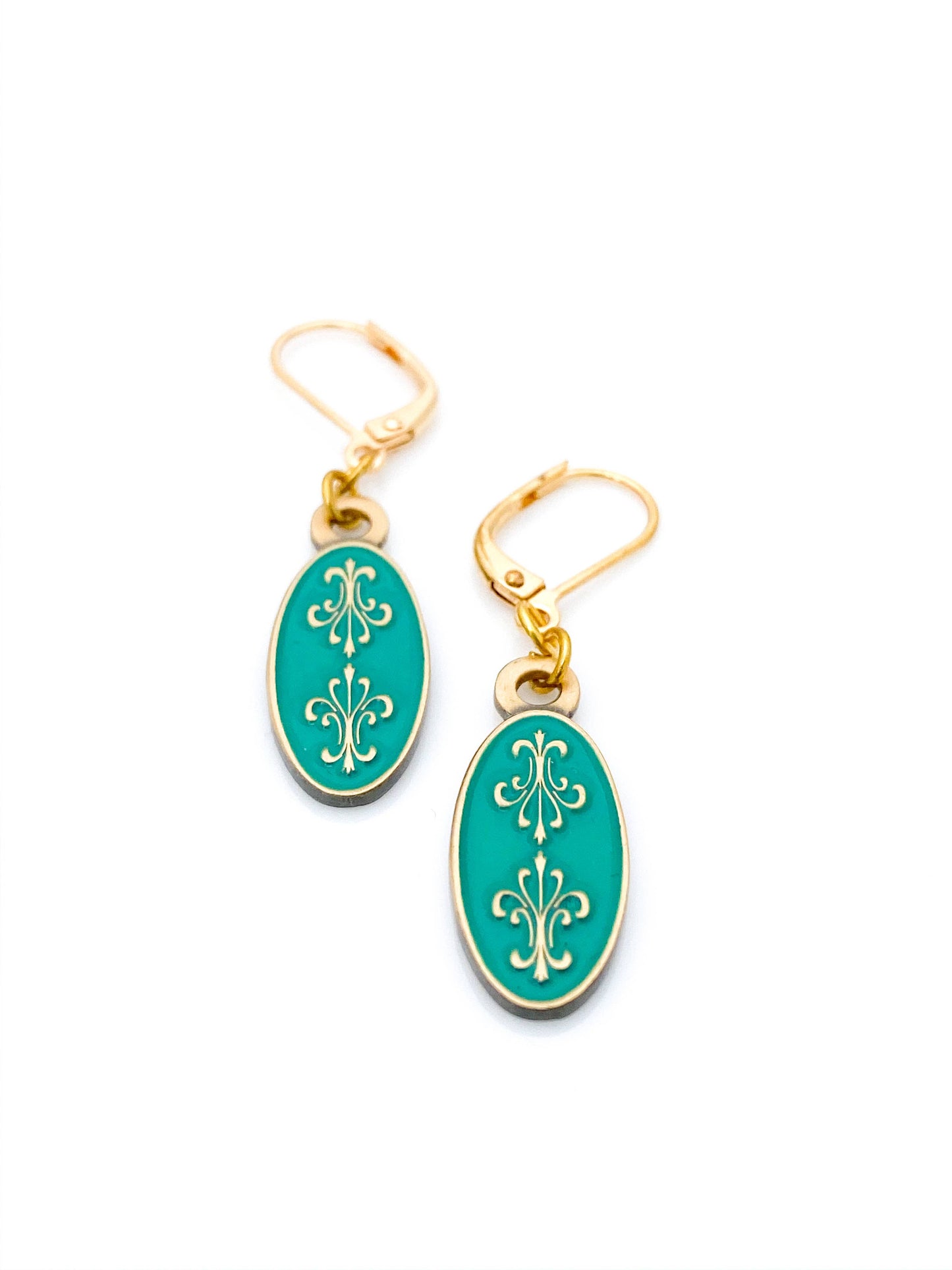 Antiqued gold oval earrings with two fleur de lys back to back on green enamel