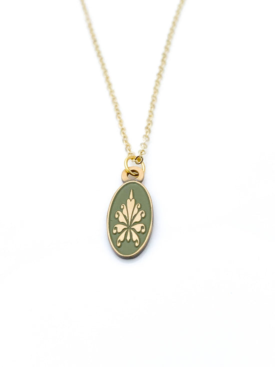 Antiqued gold oval necklace with fleur de lys pattern on green enamel