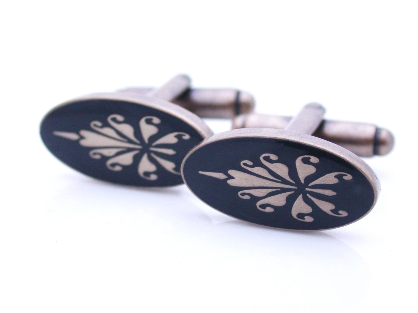 Antiqued gold oval cufflinks with fleur de lys pattern on black enamel