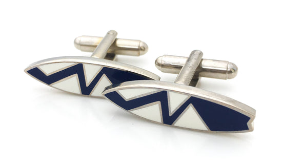 Surfboard-shaped cufflinks in navy blue enamel with a zigzag pattern.