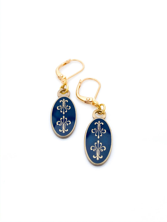 Antiqued gold oval earrings with two fleur de lys back to back on navy blue enamel