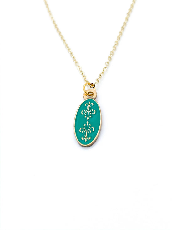 Load image into Gallery viewer, Antiqued gold oval necklace with two fleur de lys back to back on green enamel
